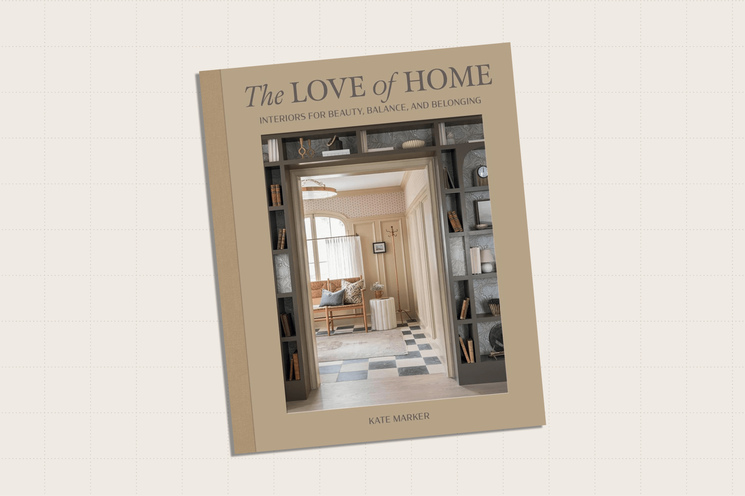 The coffee table book, "The Love of Home," with a cover showing a photo of beautiful entryway as seen through another room with floor-to-ceiling bookshelves surrounding the door frame.